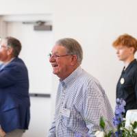 Happy Fox standing and talking with two other gentlemen at event